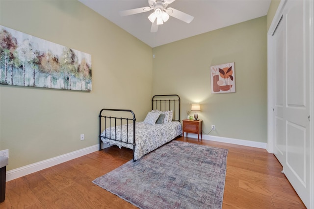 bedroom with ceiling fan, a closet, baseboards, and wood finished floors