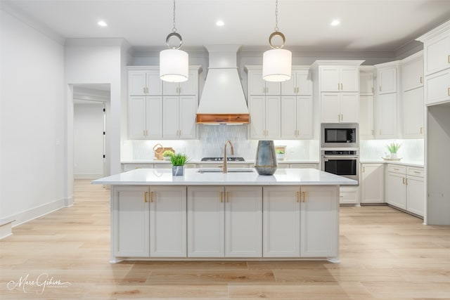 kitchen featuring stainless steel appliances, a center island with sink, custom exhaust hood, and tasteful backsplash