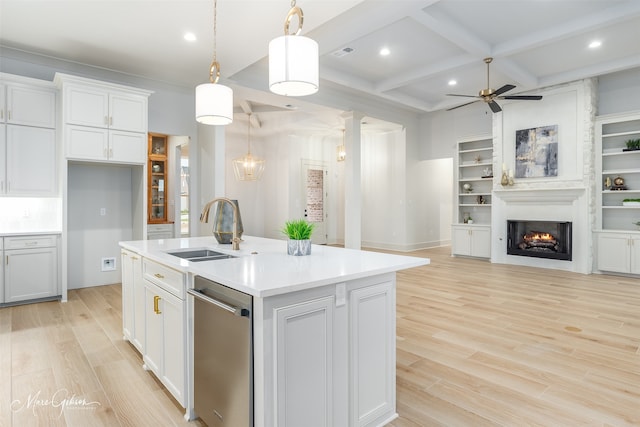 kitchen with a sink, visible vents, open floor plan, a lit fireplace, and stainless steel dishwasher