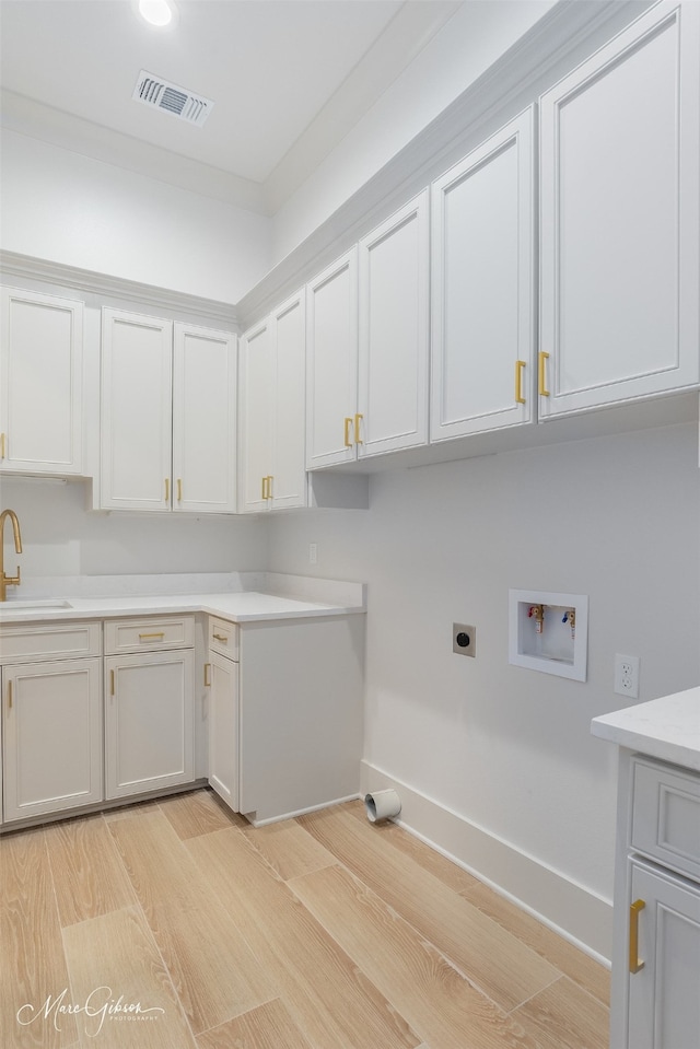 laundry area with hookup for a washing machine, cabinet space, visible vents, a sink, and electric dryer hookup