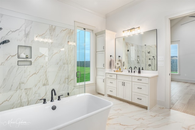 full bath with marble finish floor, crown molding, a soaking tub, a stall shower, and vanity