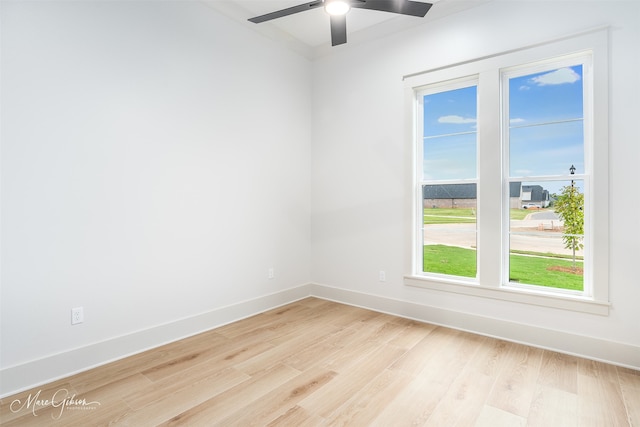 empty room featuring baseboards, ceiling fan, and light wood finished floors