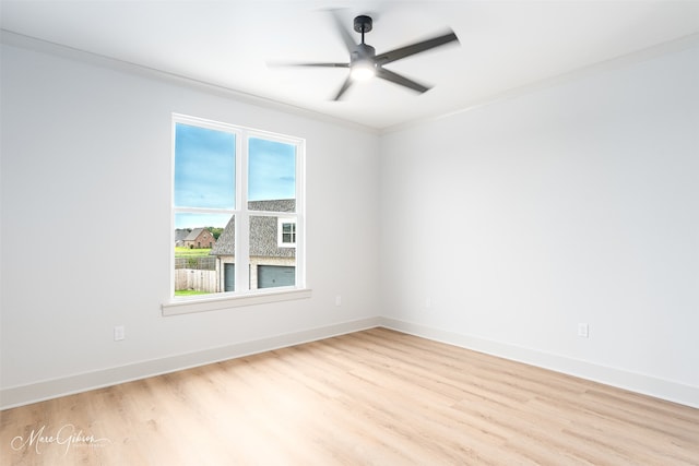 empty room featuring ceiling fan, ornamental molding, baseboards, and light wood-style floors