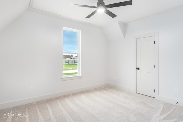 carpeted spare room with a ceiling fan, lofted ceiling, and baseboards