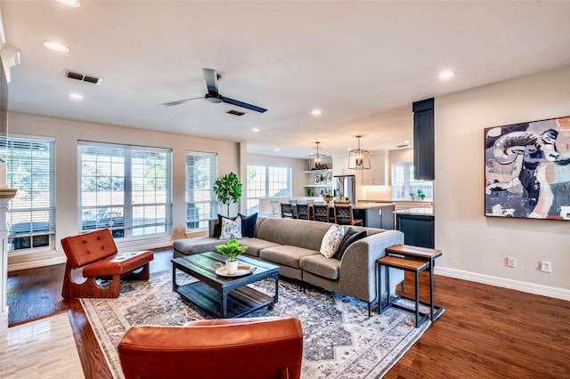 living area with visible vents, recessed lighting, and wood finished floors