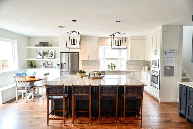 kitchen featuring a sink, dark wood-style floors, tasteful backsplash, and stainless steel appliances