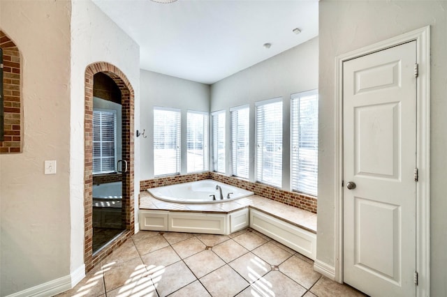 full bath with tile patterned flooring, a stall shower, baseboards, and a garden tub