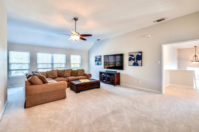 living room with a ceiling fan, visible vents, baseboards, lofted ceiling, and light colored carpet