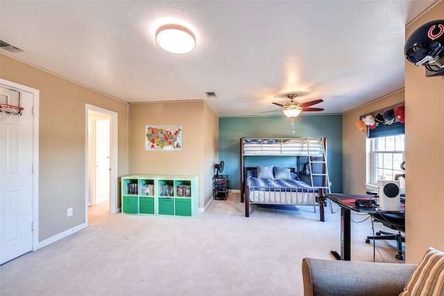 carpeted bedroom featuring visible vents, baseboards, and a ceiling fan