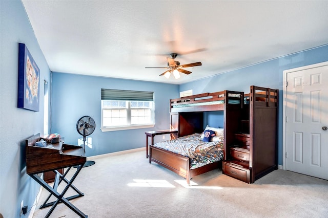 carpeted bedroom featuring baseboards and a ceiling fan