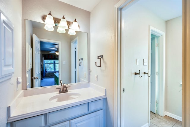 bathroom featuring vanity, tile patterned floors, baseboards, and ceiling fan