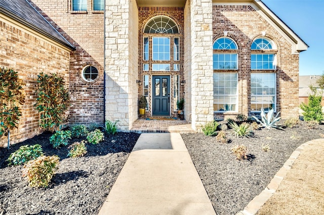 view of exterior entry featuring brick siding