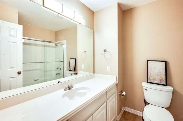 full bath featuring vanity, baseboards, tile patterned floors, toilet, and a shower with door