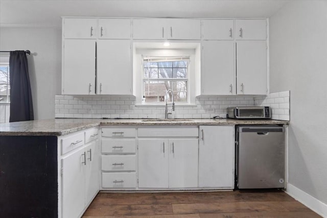 kitchen featuring dark wood-style flooring, a sink, backsplash, and stainless steel dishwasher