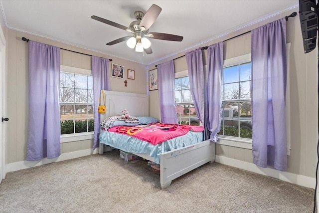 carpeted bedroom featuring multiple windows, a ceiling fan, and crown molding