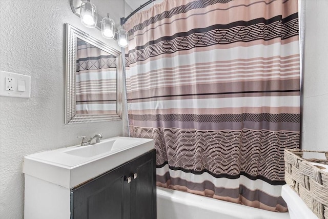 full bathroom with vanity, shower / bath combination with curtain, and a textured wall