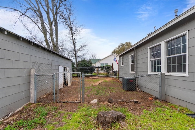 view of yard featuring a gate, fence, and cooling unit