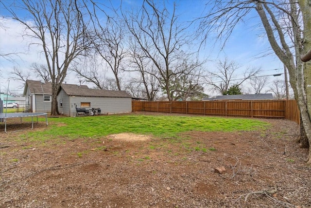 view of yard with a trampoline and a fenced backyard