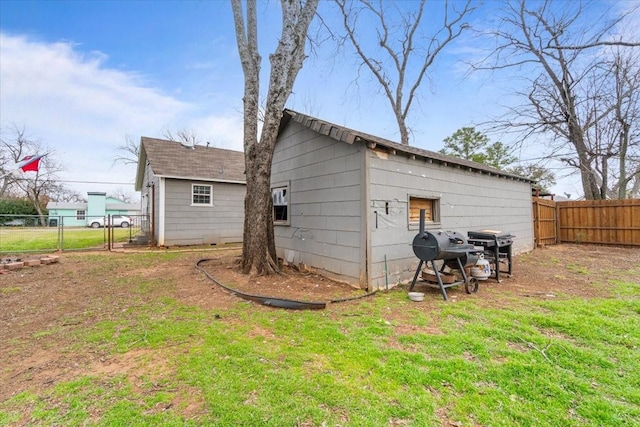 rear view of property with fence and a lawn