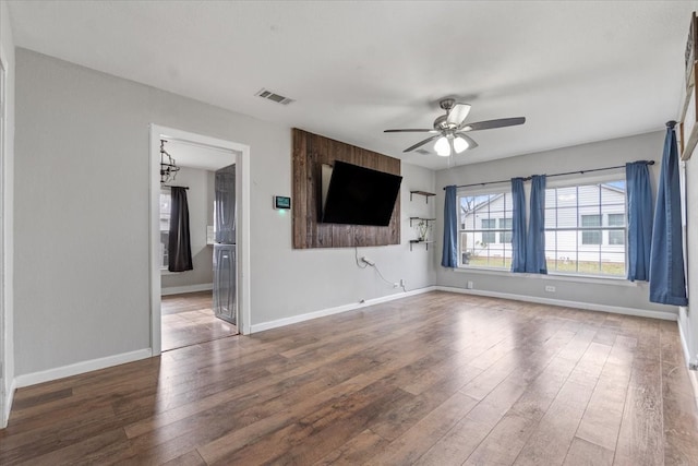 unfurnished living room with wood finished floors, a ceiling fan, and baseboards