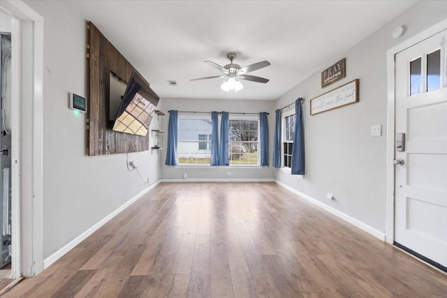 interior space with a ceiling fan, visible vents, baseboards, and wood finished floors