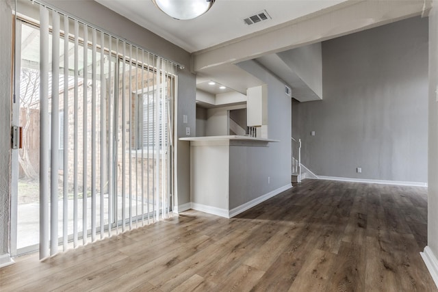 interior space featuring plenty of natural light, wood finished floors, visible vents, and baseboards