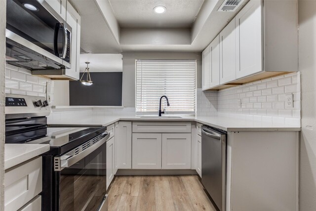 kitchen with visible vents, white cabinets, appliances with stainless steel finishes, light countertops, and a sink