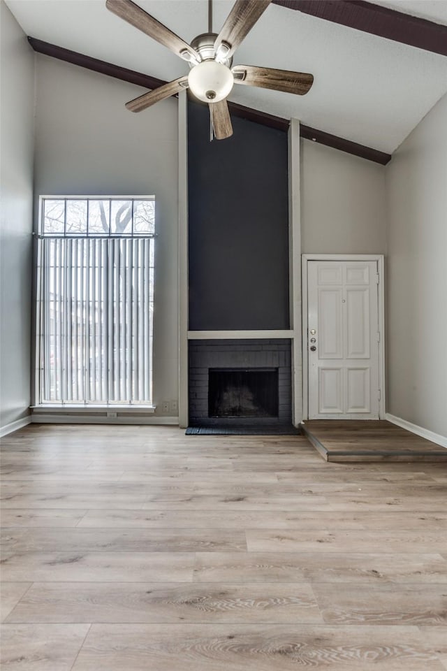 unfurnished living room featuring baseboards, ceiling fan, wood finished floors, a brick fireplace, and high vaulted ceiling