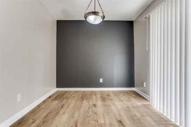 unfurnished dining area with wood finished floors and baseboards