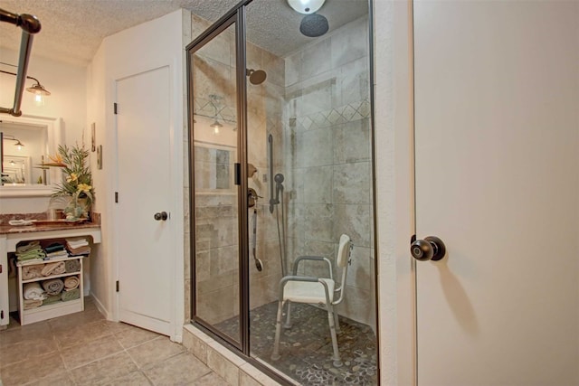 full bathroom featuring tile patterned floors, a textured ceiling, and a stall shower