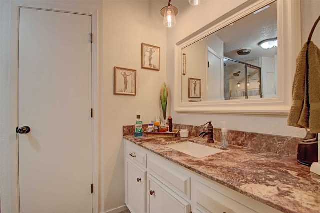 full bath with a stall shower and vanity