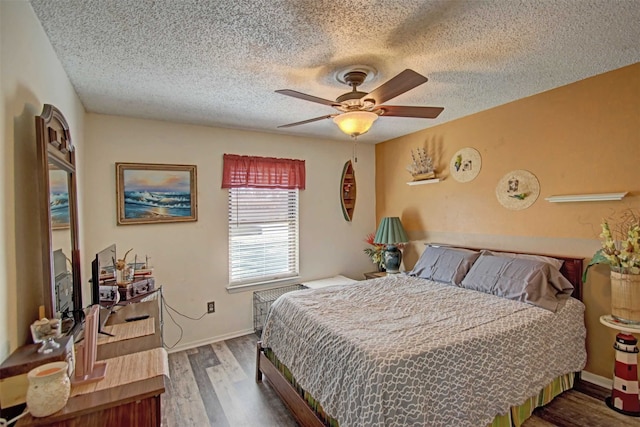 bedroom featuring a textured ceiling, a ceiling fan, and wood finished floors