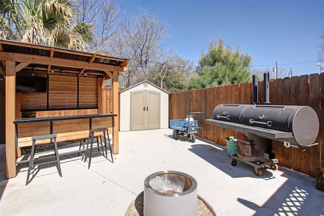 view of patio with a storage unit, an outdoor structure, and fence