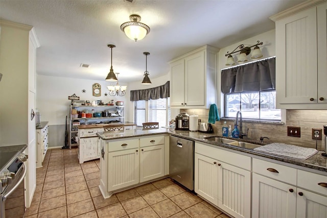 kitchen with light tile patterned floors, a peninsula, a sink, decorative backsplash, and stainless steel appliances