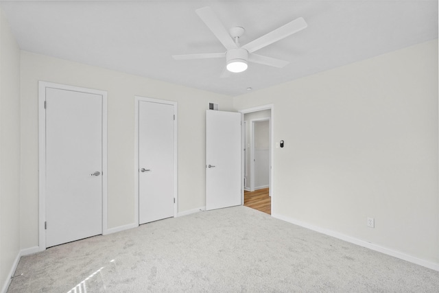 unfurnished bedroom featuring carpet floors, visible vents, and baseboards