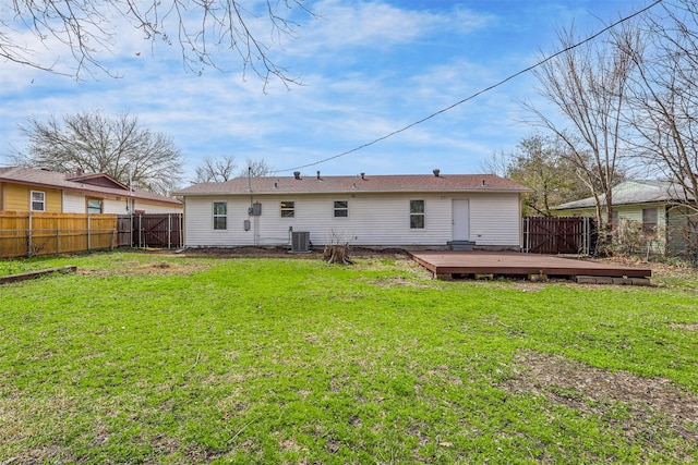 back of house with a fenced backyard, a lawn, central AC, and a wooden deck