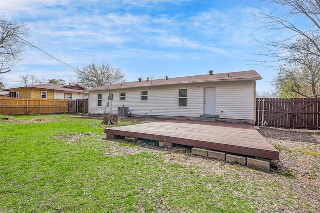 rear view of house featuring central AC unit, a lawn, a wooden deck, and a fenced backyard