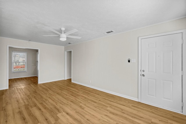 unfurnished room with visible vents, light wood-style flooring, ceiling fan, a textured ceiling, and baseboards