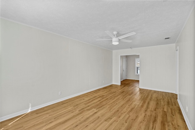 unfurnished room featuring light wood-type flooring, a textured ceiling, visible vents, and a ceiling fan