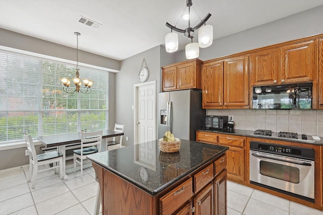 kitchen featuring appliances with stainless steel finishes, brown cabinetry, and tasteful backsplash