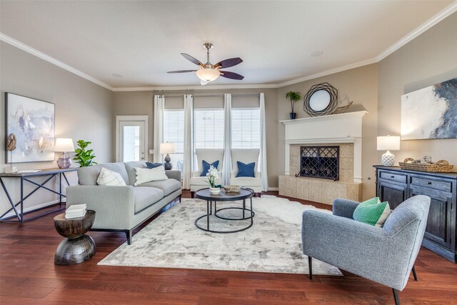 living room featuring a fireplace, crown molding, ceiling fan, and wood finished floors