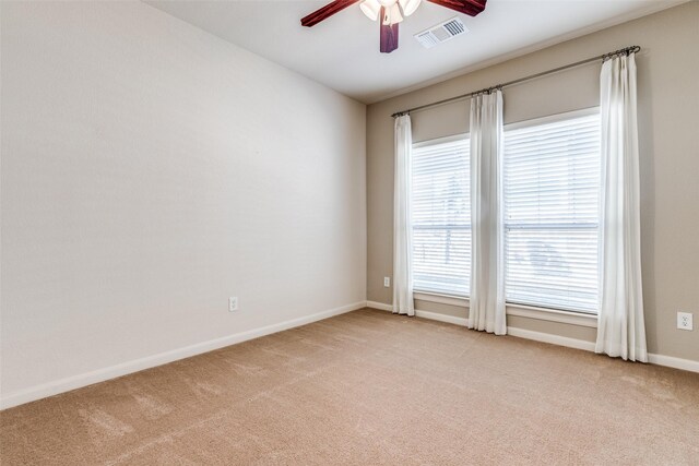 spare room featuring baseboards, light colored carpet, visible vents, and ceiling fan