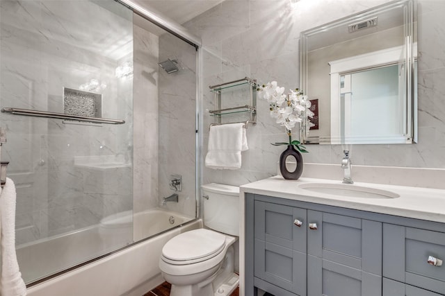 bathroom featuring visible vents, vanity, toilet, and tile walls