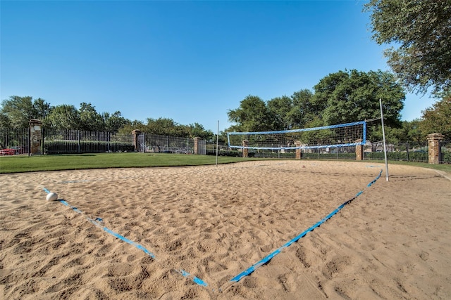 view of home's community with fence, volleyball court, and a lawn