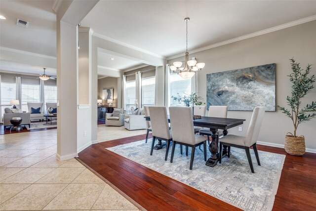 dining room with a healthy amount of sunlight, wood finished floors, and crown molding