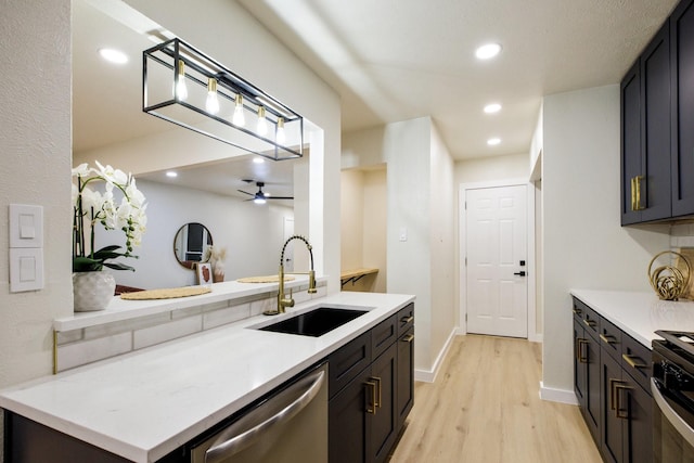 kitchen featuring dishwasher, light wood finished floors, a sink, and light countertops