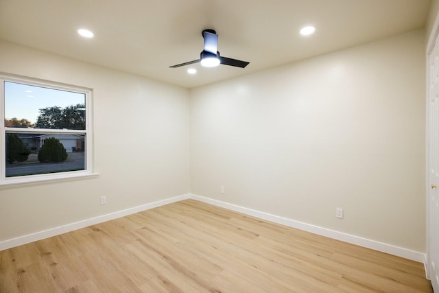 spare room featuring light wood finished floors, recessed lighting, and baseboards