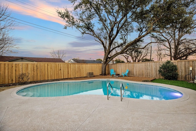 pool at dusk featuring a fenced backyard, a fenced in pool, and a patio