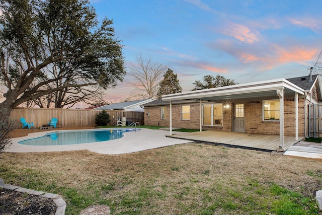 pool at dusk featuring a fenced backyard, a patio, a fenced in pool, and a yard