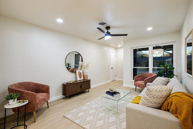 living room featuring light wood finished floors, baseboards, visible vents, and recessed lighting